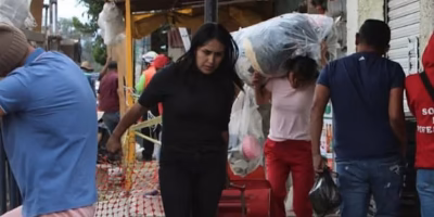Family rescues belongings in front of a sinkhole in Iztapalapa